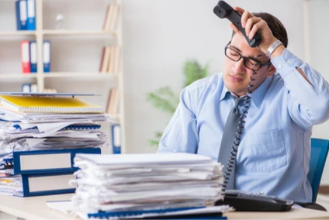 Busy business owner overwhelmed with calls and paperwork